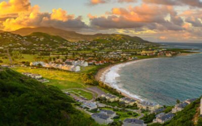 Panorama of Saint Kitts and its capital Basseterre during sunset, beautiful green mountains and a beach in paradise caribbean island with amazing green and orange colors